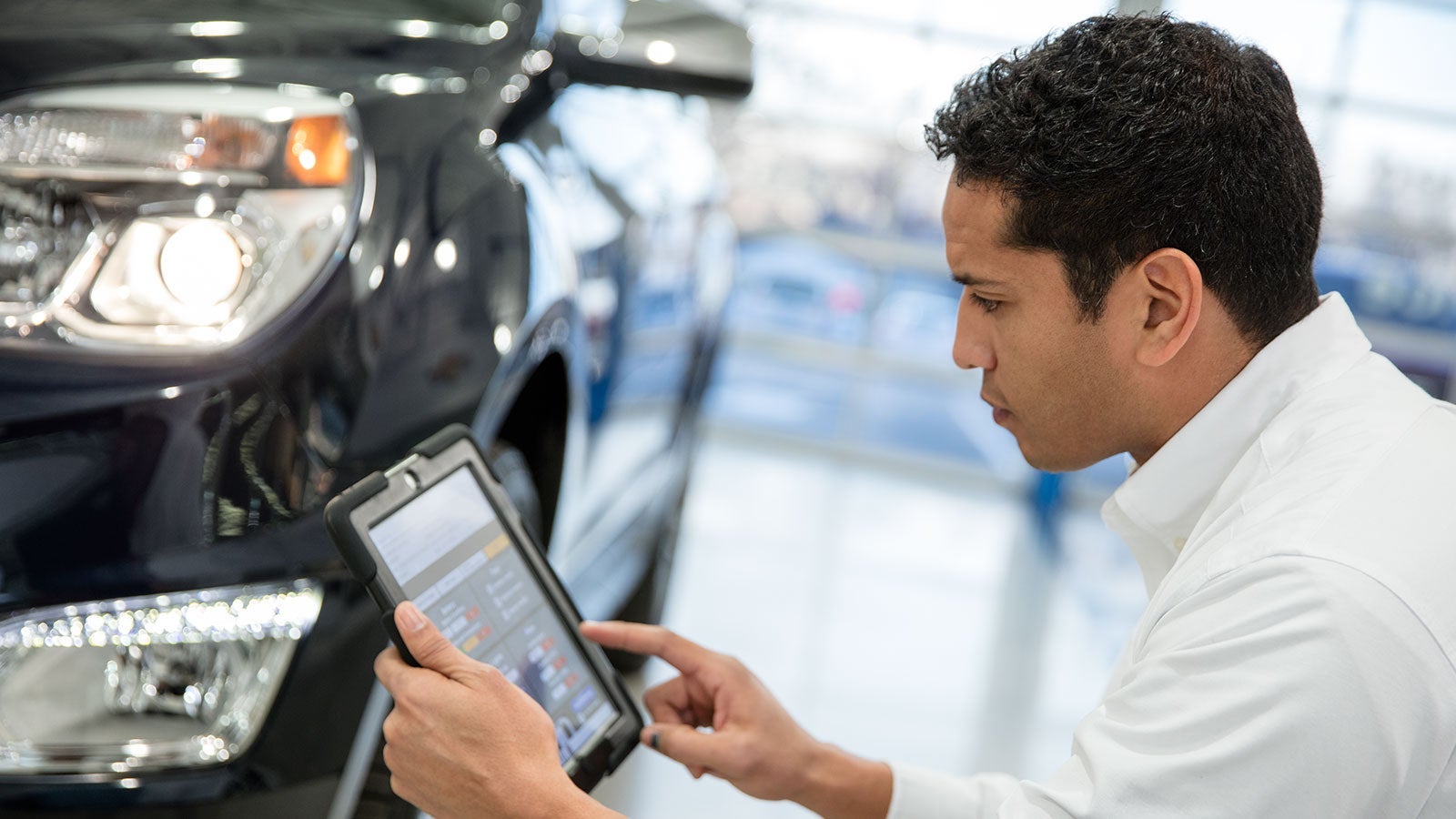 Mechanic working on car in shop