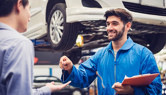 Mechanic handing car keys to customer